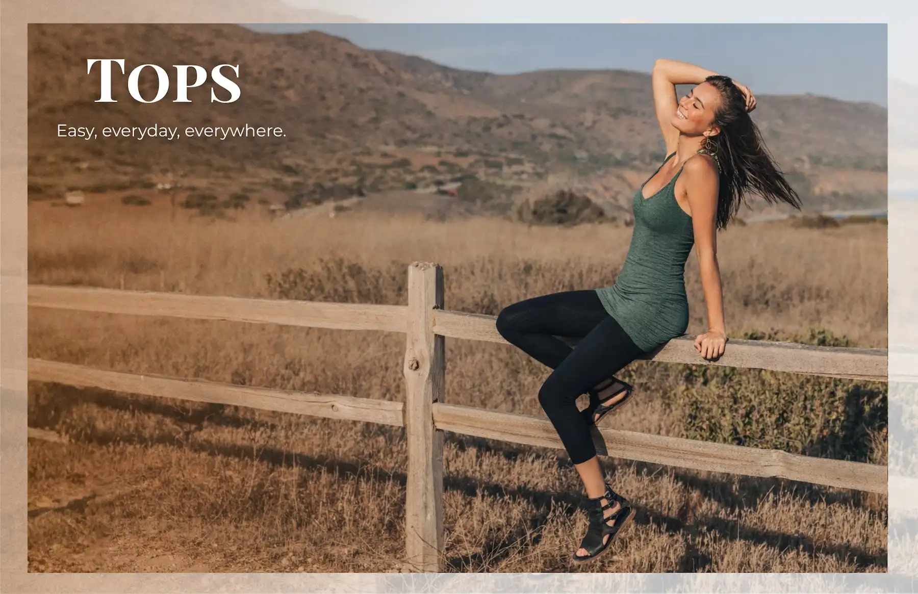 Woman sitting on a fence in a top that is easy, everyday, everywhere.